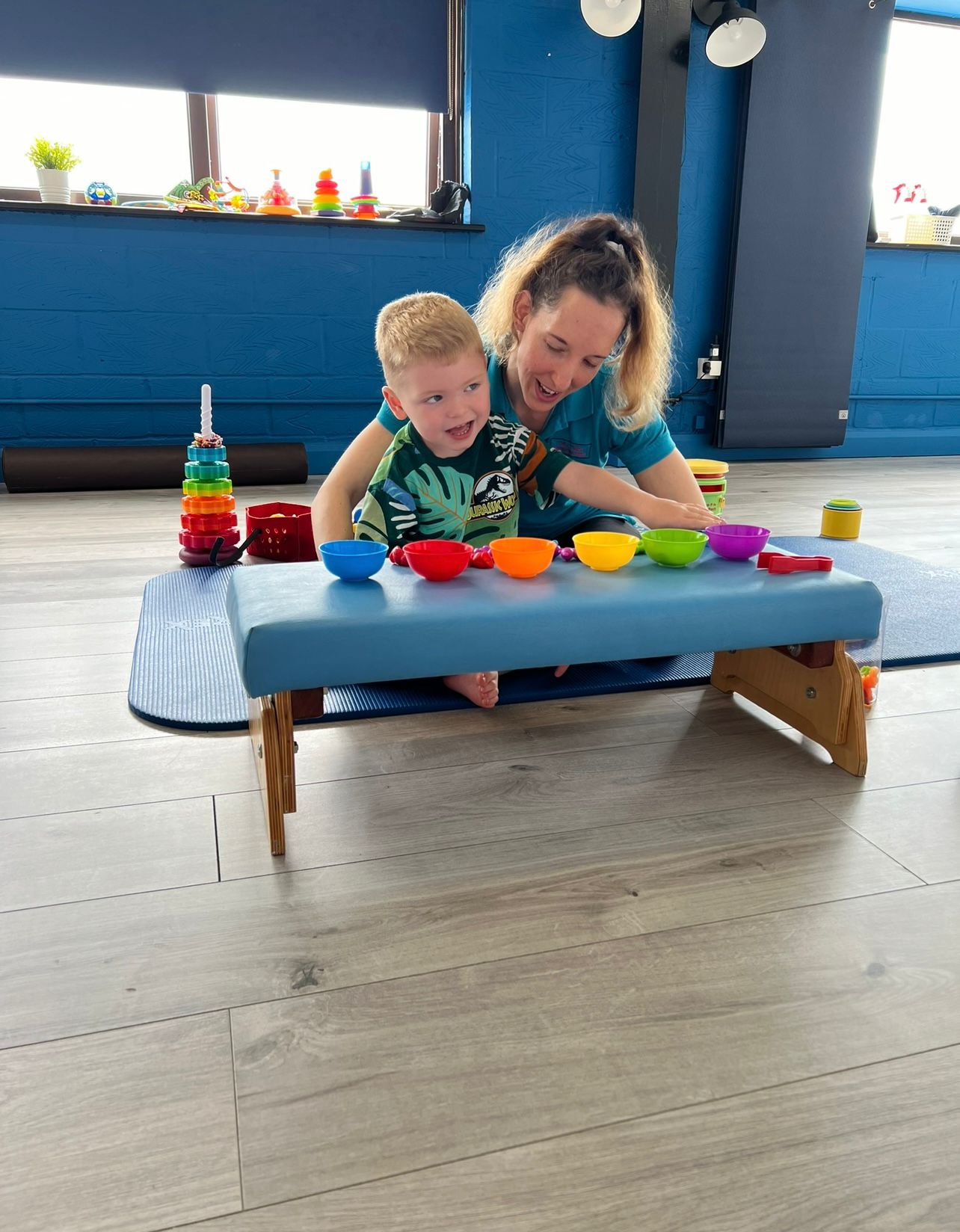 Child physio session in Sandy — paediatric physiotherapist with a young child during a colourful bowls activity