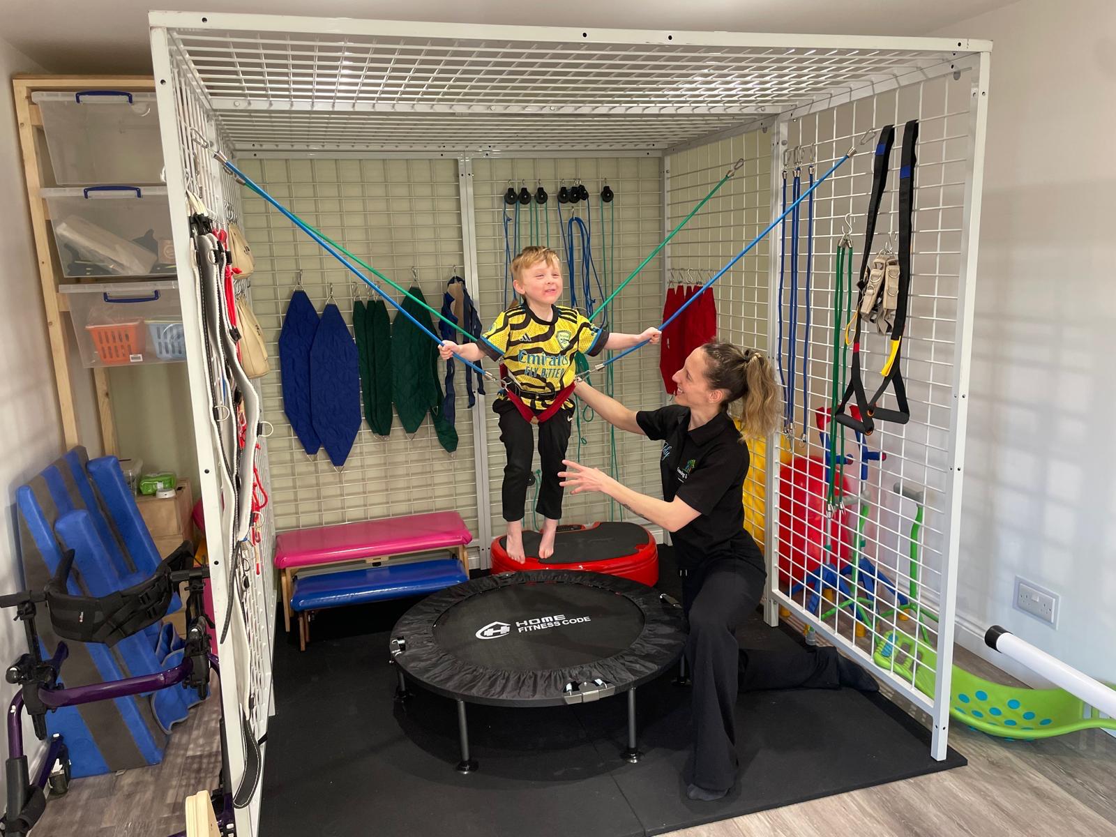 Physiotherapist supporting a child during Spider Cage Therapy